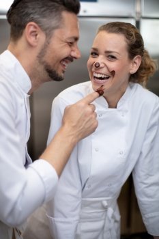 man and woman having fun with chocolate in icecream factory
