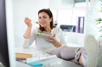 woman eating salad in an office
