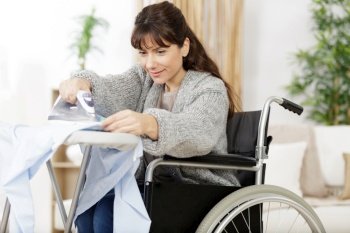 disabled woman ironing at home and smiling