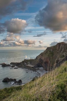 Beautiful sunrise landscape image of Devon coastline in England with stunning golden hour light on the land and sky
