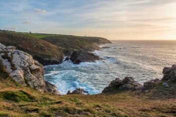 Beautiful sunset landscape image of Cornwall cliff coastline with tin mines in background viewed from Pendeen Lighthouse headland