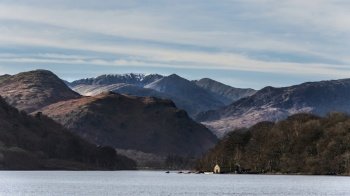 Beautiful Winter landscape views of mountain ranges around Ullswater in Lake District viewed from boat on lake