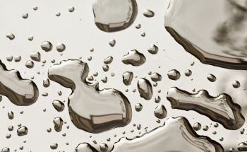 Water drops over black reflecting surface, horizontal image