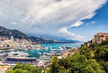 Principality of Monaco. Beautiful panoramic view on Monaco, golden hour scenery. View on apartment building, casino, great port with luxury yachts. Monaco is popular travel destination, wealth symbol