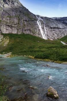 blue glacial water of Briksdal River in Norway