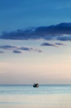 fishing boat in the ocean at sunset