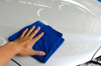 Hand man worker use clean blue cloth to wipe the car