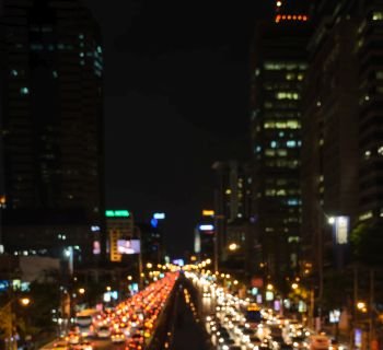 Blurred bokeh image of traffic jam  in business area downtown. Defocused image of city night light