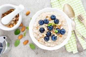 Oatmeal with fresh blueberry, almond nuts and honey for breakfast