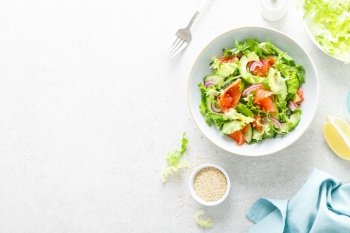 Salmon avocado salad with salted fish, lettuce, red onion and cucumbers