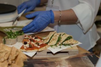 A Chef Preparing Appetizers based on Pieces of Pizza and Stuffed Italian Piadina.. A Chef Preparing Appetizers based on Pieces of Pizza and Stuffed Italian Piadina
