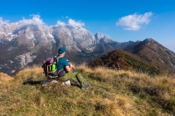 Man hiker sit and watch the landscape of  mountain in autumn from the mountain top
