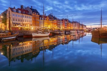 Multicolored facades of old medieval houses and ships along the canal of Nyhavn. Denmark.. Copenhagen. The Nyhavn channel is at dawn.