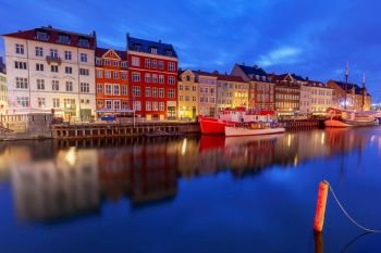 Multicolored facades of old medieval houses and ships along the canal of Nyhavn. Denmark.. Copenhagen. The Nyhavn channel is at dawn.