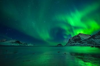 wonderful night sky with northern lights over a beach with reflections, lofoten, norway