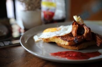 Breakfast french toast with bacon egg and cheese with jam on wood table background
