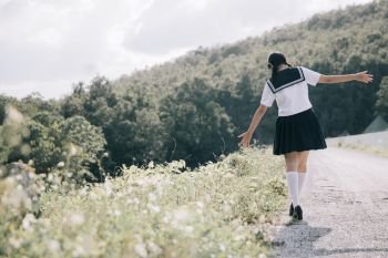 Portrait of asian japanese school girl costume walking at park outdoor film vintage style