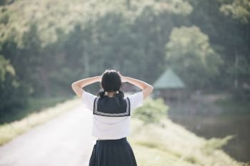 Portrait of asian japanese school girl costume looking at park outdoor film vintage style