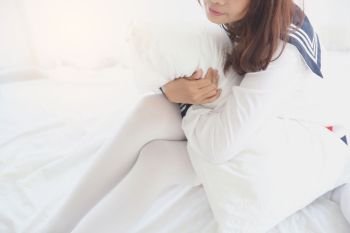 Asian girl wake up with school girl uniform in bedroom