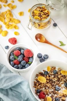 Light healthy breakfast with cereal and berries on the white wooden table, selective focus 