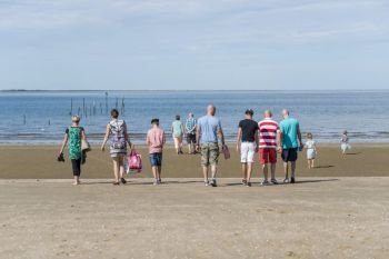 Rockanje,Holland,29-aug-2018,big family with grandpa grandma mother father and chlidren walking on the beach to the sea on a summer day. big family to the beach