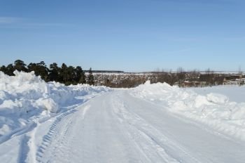 Snowy road in small russian town Kolchugino, Vladimir region, Russia. Sunny day in early spring.