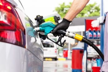 Man filling diesel fuel in car at gas station
