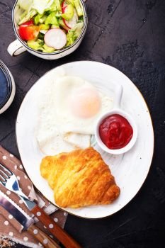 breakfast on a table, fried eggs and croissant