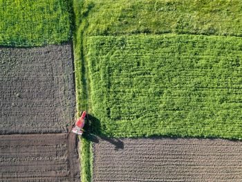 Aerial view of field,farmland cultivated. Tractor working in the field. Photo from the drone. Agriculture. Aerial view of farmland in Spring