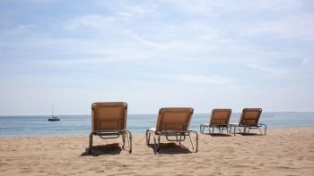 Four beach chairs on the beach. Spain, Barcelona beach. Four beach chairs on the beach.