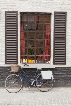 Retro bicycle standing near the old window, Belgium. Vintage bike Brick wall window
