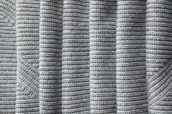 A full page of a loose gray knit fabric texture. full page of a loose gray knit fabric texture
