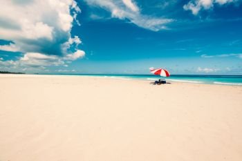 Wonderful  beach of Varadero during a sunny day, fine white sand and turquoise and green Caribbean sea,on the right one red parasol,Cuba.concept  photo,copy space.Vintage style.