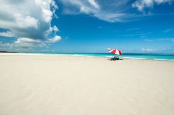 Amazing beach of Varadero during a sunny day, fine white sand and turquoise and green Caribbean sea,on the right one red parasol,Cuba.concept  photo,copy space.