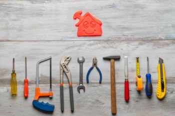 Set of work tool on gray wooden background with icon of house in space, industry engineer tool concept.still-life.