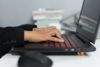 Close-up of hands typing on laptop keyboard