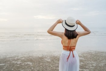 cheerful woman in bikini standing at the sea beach