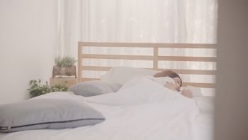 Asian woman dreaming while sleeping on bed in bedroom, Beautiful japanese female using relax time lying on bed at home. Lifestyle women using relax time at home concept.