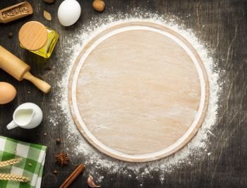 wheat flour and cutting board on wooden background, top view