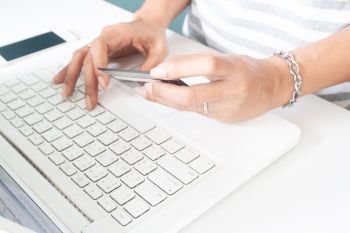 Woman’s hands using laptop and credit card. Online payment, internet banking
