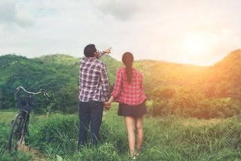 Young hipster couple holding hands walking on the meadow relaxin. Young hipster couple holding hands walking on the meadow relaxing and natural atmosphere is very natural.