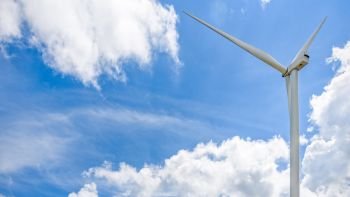 Beautiful wind turbine on blue sky and white clouds background, Eco-friendly electric power source help reduce global warming, 16:9 wide screen. Wind turbine on sky