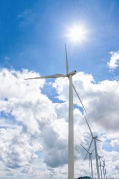 Beautiful windmill under the sun on blue sky and white clouds background, Clean energy eco-friendly electric power source help reduce global warming. Windmill under the sun