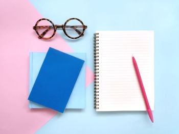 Creative workplace on pink and blue background.
