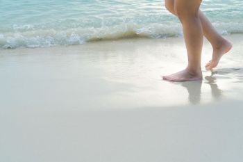 Beach travel - blur girl’s walking on the white sand beach, vacation and relax - soft skin filter