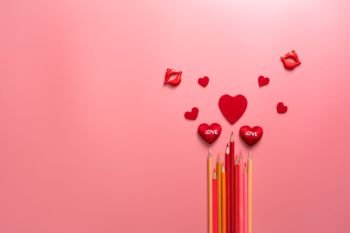Valentine Day concept, red hearts and color pencil on pink background