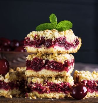pile of baked cake with cherry , close up