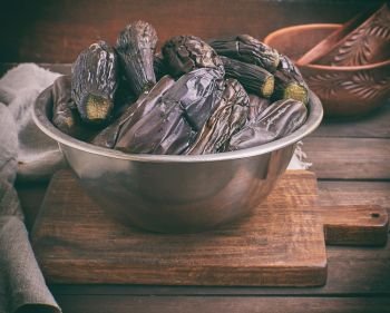 fresh boiled eggplants in an iron bowl, vintage toning 