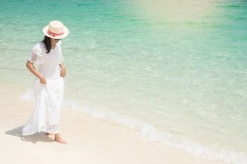 a beautiful carefree Woman relaxing at the beach enjoying her sun dress freedom wear