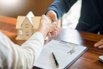 House developers agent or financial advisor and customers shaking hands after signing document making deal as successful agreement, contract with a firm